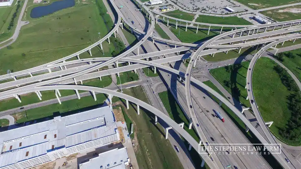 Aerial view of a complex highway intersection featuring multiple lanes and vehicles in motion.