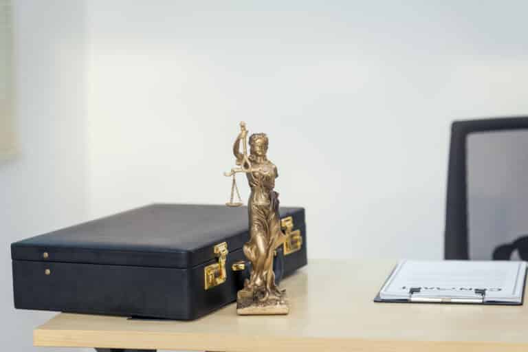 a lawyers desk with a justice trophy