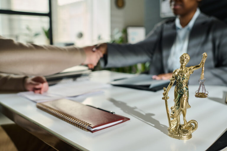 attorney at their desk shaking clients hand