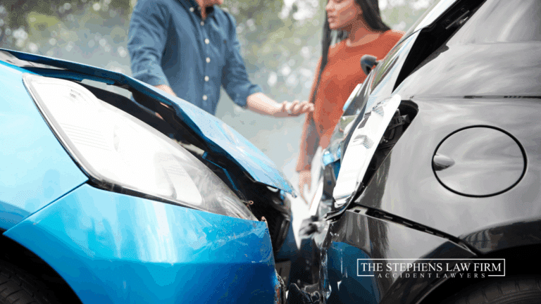 blue car hit a black car in a rear-end collision and two people are arguing about the accident
