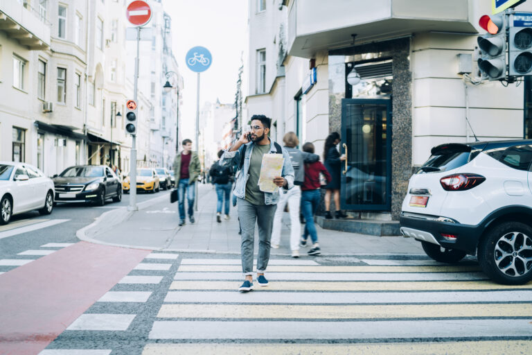 person crossing the pedestrian walkway while talking on the phone