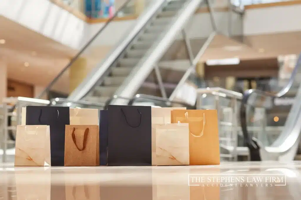 paper shopping bags on the floor in mall with escalator in the background